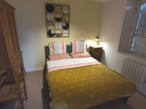 ein kleines Schlafzimmer mit einem Bett mit einer gelben Decke in der Unterkunft Cosy'Appart hyper centre Josselin in Josselin