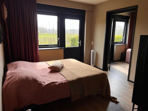 1 dormitorio con cama y ventana en Parsingel en Oostermeer