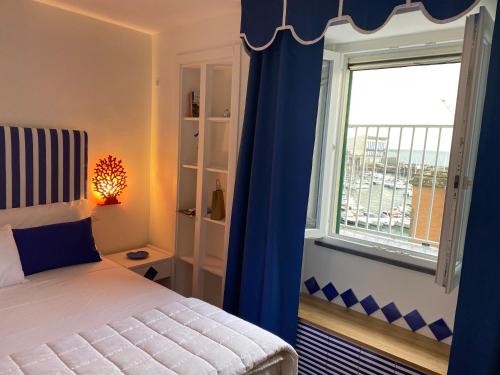 ein Schlafzimmer mit einem Bett und einem großen Fenster in der Unterkunft Appartamento vista mare Aria 'e mare tra Pompei e Sorrento in Castellammare di Stabia