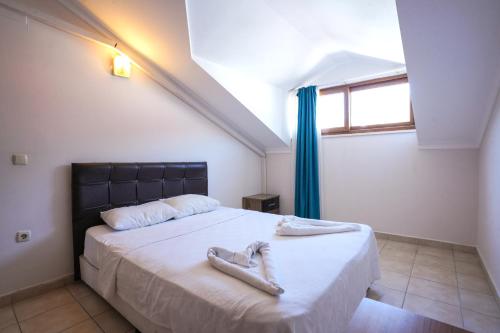 ein Schlafzimmer mit einem Bett mit einem Paar Schuhe darauf in der Unterkunft Four Seasons Apart Hotel in Dalyan