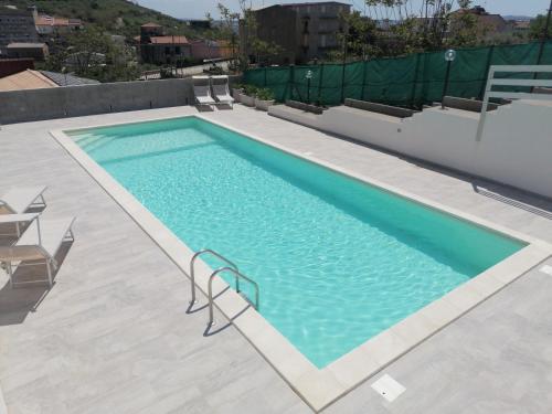 a swimming pool with blue water in a building at Casa Vacanze Villa Tropia in Camastra ex Solfara