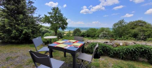 ein Tisch und Stühle mit Blick auf ein Feld in der Unterkunft Gîte à la tour de Peyrebrune in Alrance