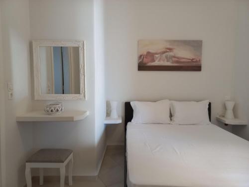 Habitación blanca con cama y espejo en Solid Residence, en Triovasálos