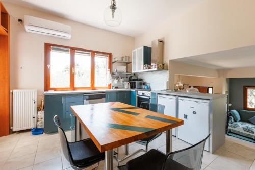 a kitchen with a wooden table and some chairs at Large Home near Potamos Beach in Epanomi