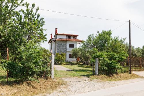 a house on the side of a road with trees at Large Home near Potamos Beach in Epanomi