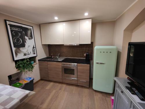 a kitchen with a green refrigerator and a sink at Torre Paola Dimora romantica in Acquasparta