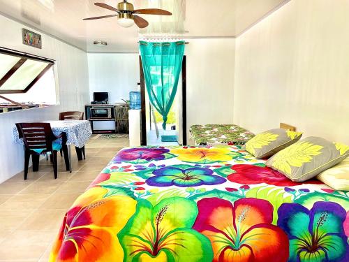 a colorful bed in a room with a kitchen at Tikehau cosy lodge in Tikehau