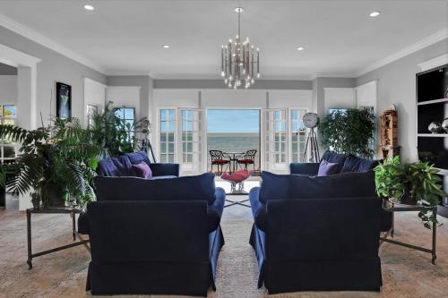 a living room with blue furniture and a view of the ocean at Somerset - A Private Retreat in Niagara on the Lake