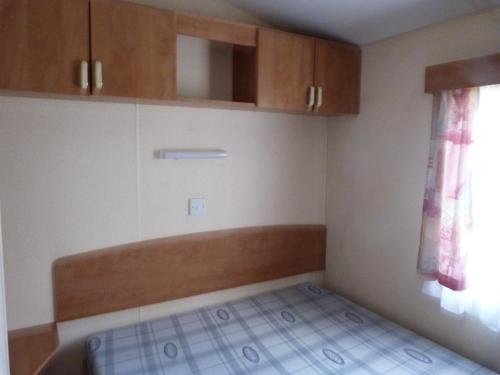 Il comprend une petite cuisine avec des placards en bois et du carrelage. dans l'établissement camping la rivière, à Vabre-Tizac