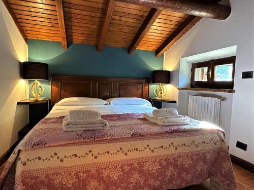 a bedroom with a large bed with two towels on it at L'antico Borgo in Cremia