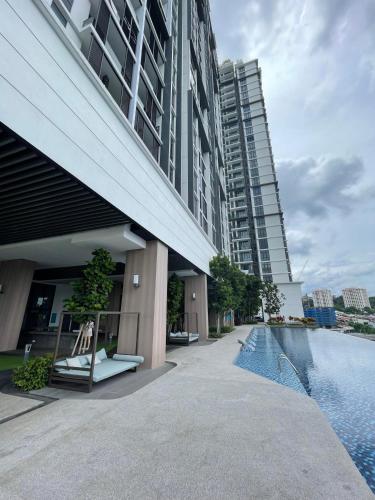 a building with a swimming pool next to some buildings at Luxury Studio Apartment with KL Breathtaking View in Kuala Lumpur