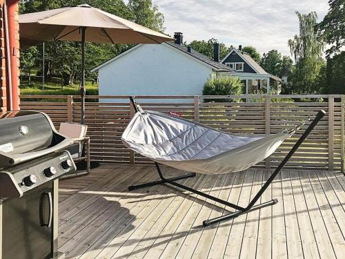 a hammock on a deck next to a grill at 5 person holiday home in BANKERYD in Bankeryd