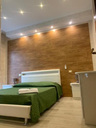 a bedroom with a green bed with two towels on it at Appartamento La Casa di Anna in San Severo
