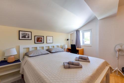 a bedroom with a large bed with two pillows on it at Apartments Valeria, Mali Lošinj in Mali Lošinj