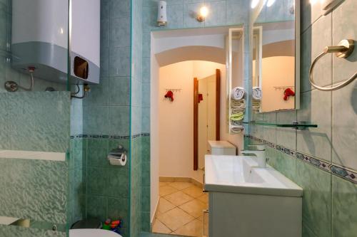 uma casa de banho com um lavatório, um WC e um espelho. em Apartments Valeria, Mali Lošinj em Mali Lošinj