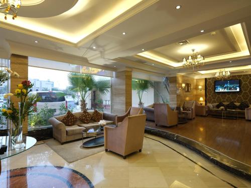 un vestíbulo con sofás y TV en un edificio en Boudl Kuwait Al Fahahil en Kuwait