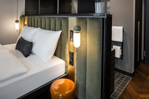 a small bedroom with a bed with white pillows at AMANO Home Leipzig in Leipzig