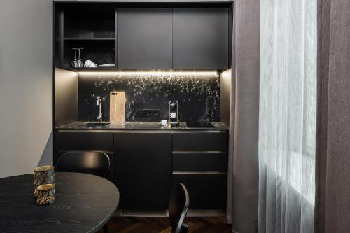 a kitchen with a sink and a table with chairs at AMANO Home Leipzig in Leipzig