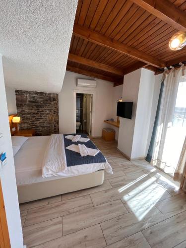 a bedroom with a bed and a television in it at Yelken Hotel Akyaka in Akyaka