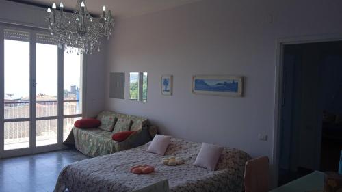 a living room with a bed and a chandelier at Casa Alessandra in Lerici