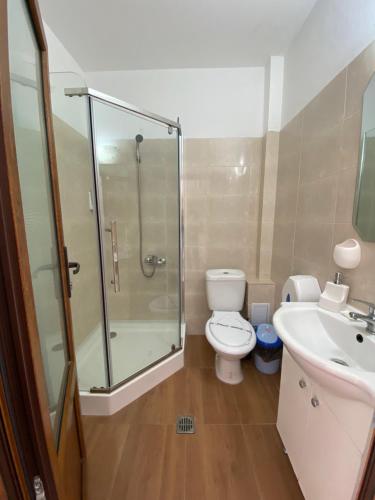 a bathroom with a shower and a toilet and a sink at Kherim in Vama Veche