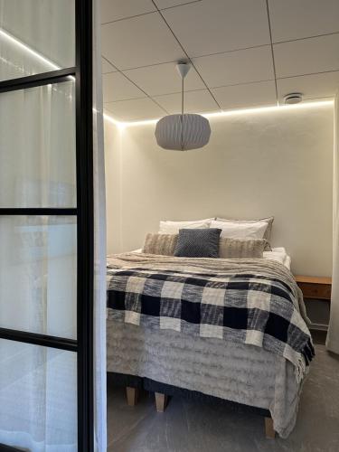 1 dormitorio con 1 cama con manta blanca y negra en Pappila Boutique Apartments en Jyväskylä