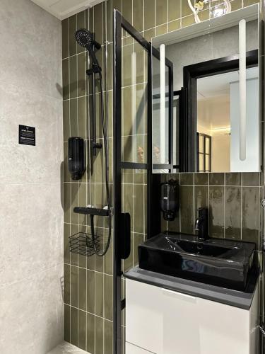 a bathroom with a black sink and a mirror at Pappila Boutique Apartments in Jyväskylä