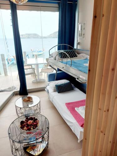 a room with two bunk beds and a balcony at Mpitzarakis Studio On the Beach in Agia Pelagia