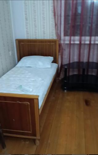 a small bed in a room with a wooden floor at Village Jazz in Chimankend