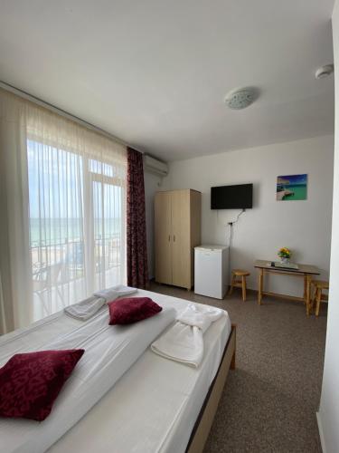 a bedroom with a large bed with a large window at Kherim in Vama Veche