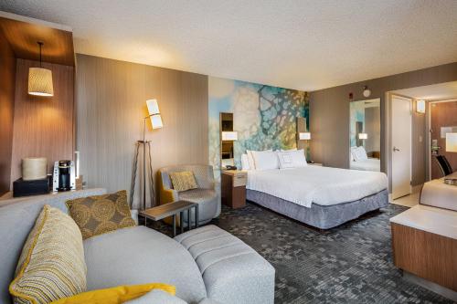 a hotel room with a bed and a couch at Courtyard by Marriott Riverside UCR/Moreno Valley Area in Riverside