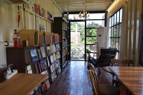 a room with a library with book shelves and a table at Jo and Lee Kids House in Seogwipo