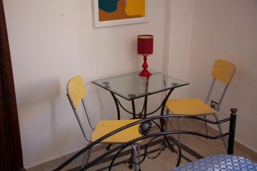 a glass table and two chairs with a candle on it at SAN FRANCESCO 67 - Erice Vetta in Erice