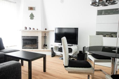 a living room with a table and a tv at Villa 6pax baby friendly Near Dino Park&Beaches in São Bartolomeu
