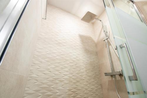 a shower with a glass door in a bathroom at Villa 6pax baby friendly Near Dino Park&Beaches in São Bartolomeu
