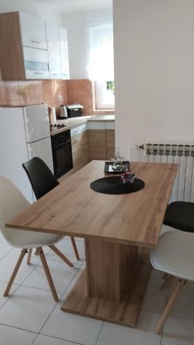 a wooden dining table in a kitchen with chairs at Dvije lipe in Moravice