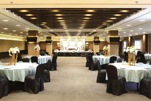 a banquet hall with white tables and black chairs at Four Points by Sheraton Lahore in Lahore