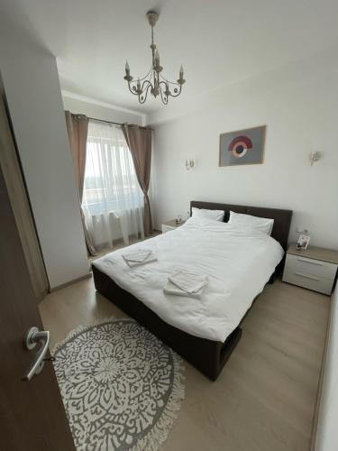 a bedroom with a bed and a chandelier at East View by DAT Apartments in Cluj-Napoca