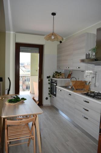 una cucina con tavolo in legno e una sala da pranzo di Appartamento Centro dei Venti a Montesilvano