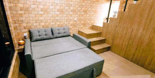 a bench in a room with a brick wall at Freja House @ Central BSD in Samporo