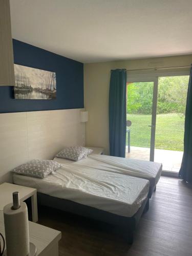 a bedroom with two beds and a large window at Studio meublé in Arles