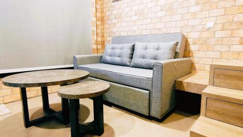 a chair and two tables in a room at Freja House @ Central BSD in Samporo