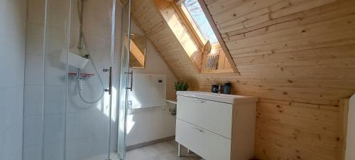 a bathroom with a shower and a sink and a window at Orfűi Gomba Vendégház in Orfű