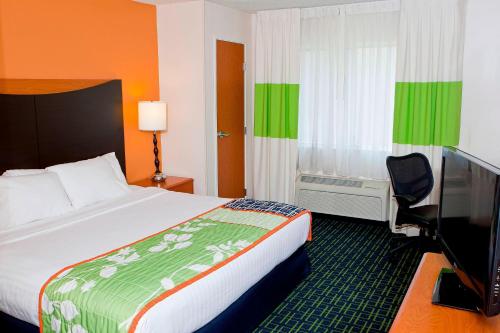 a hotel room with a bed and a flat screen tv at Fairfield Inn by Marriott Forsyth Decatur in Forsyth