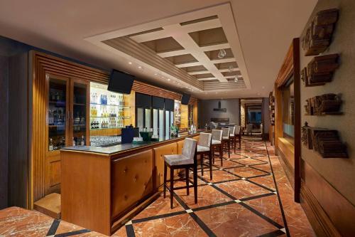 a bar with a row of stools in a restaurant at Hyderabad Marriott Hotel & Convention Centre in Hyderabad