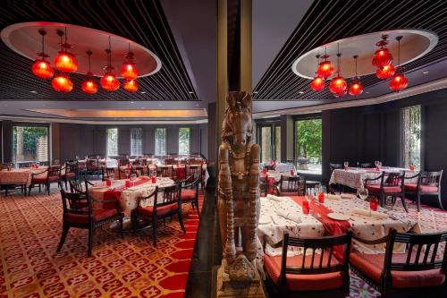 a dining room with tables and chairs and red lights at Hyderabad Marriott Hotel & Convention Centre in Hyderabad