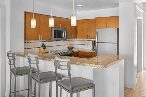 a kitchen with a counter with chairs and a refrigerator at Marriott's Desert Springs Villas II in Palm Desert