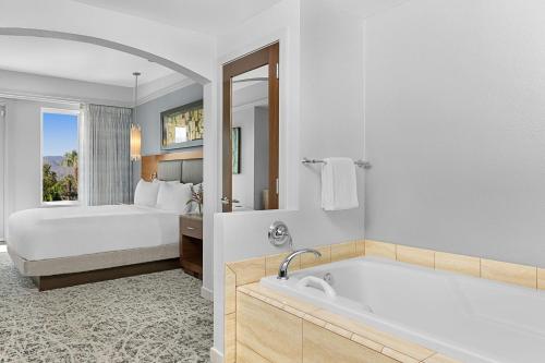 a bathroom with a bed and a tub and a bedroom at Marriott's Desert Springs Villas II in Palm Desert