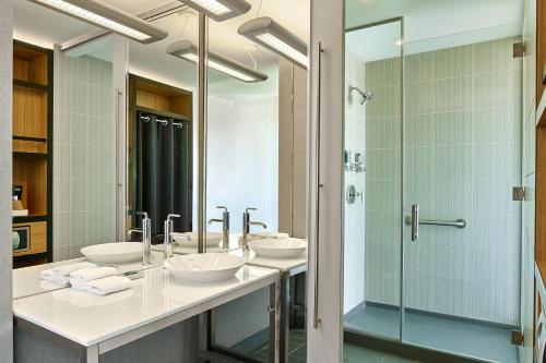 a bathroom with three sinks and a shower at Aloft Broomfield Denver in Broomfield