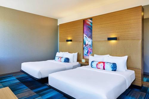 2 camas blancas en una habitación de hotel en Aloft Broomfield Denver, en Broomfield